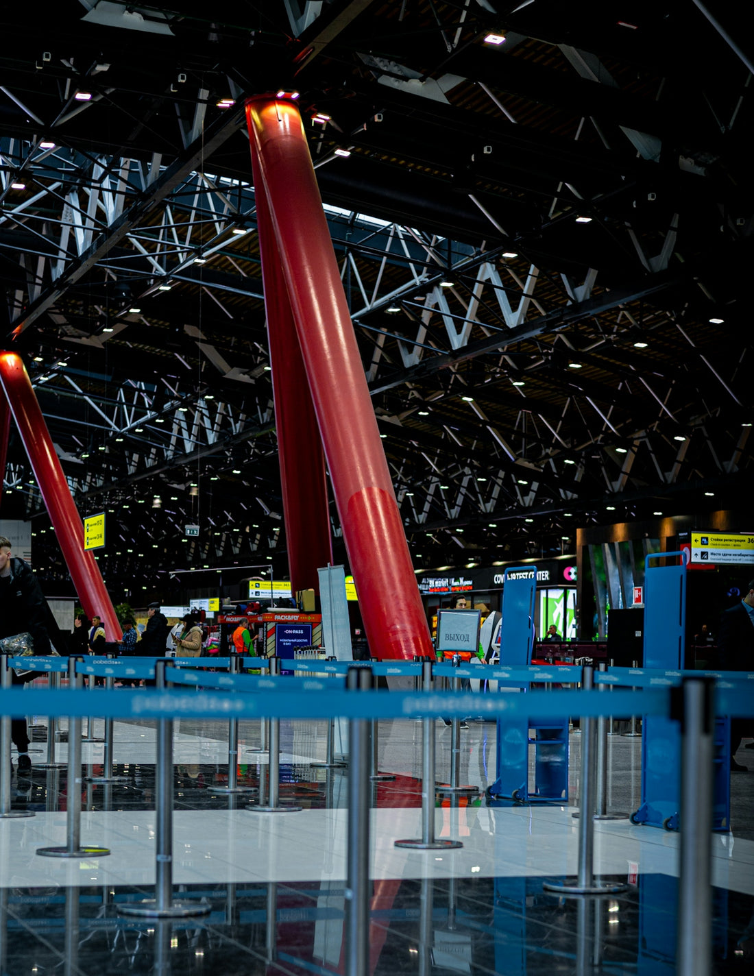 a large metal structure with red poles in a building