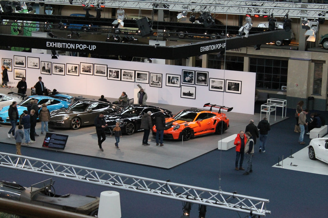 a group of people standing around a car show