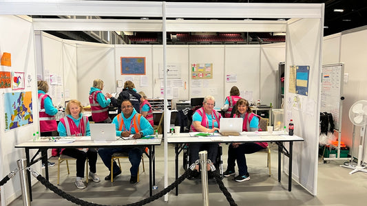 a group of people sitting at a table with laptops
