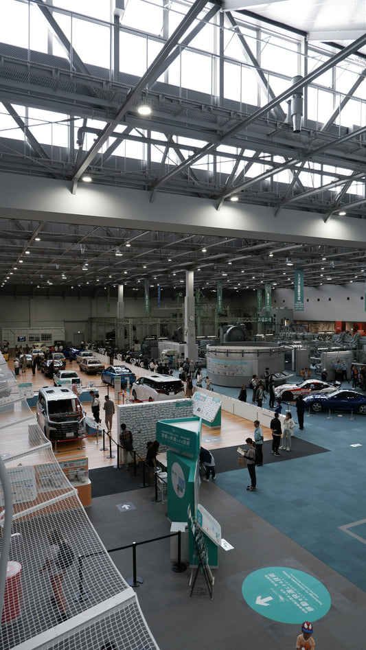 Cars displayed at an indoor exhibition hall with visitors
