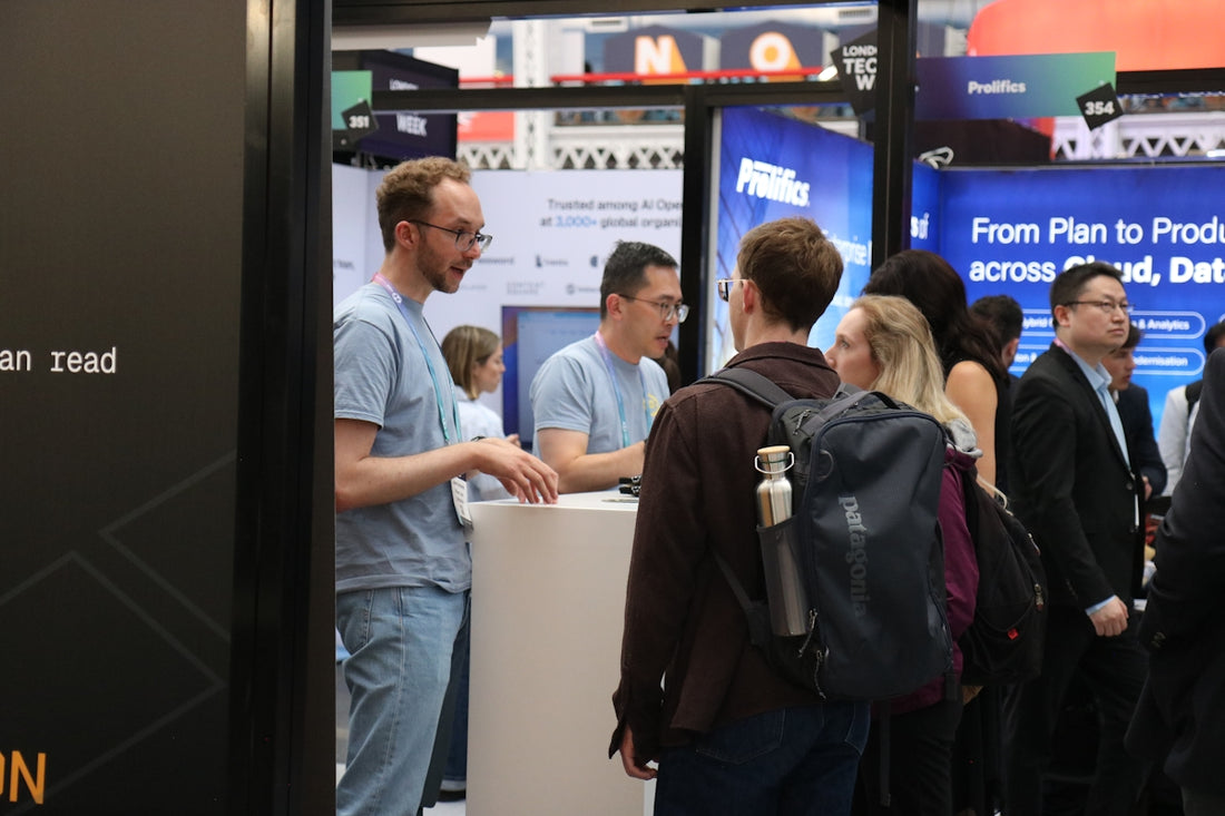 People interacting at a busy trade show booth.